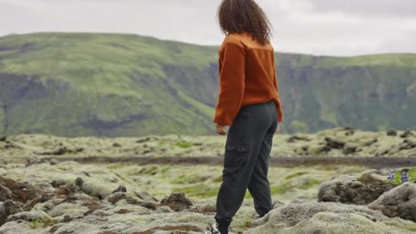 Kvinnan går i Rocky Moss täckt landskap — Stockvideo