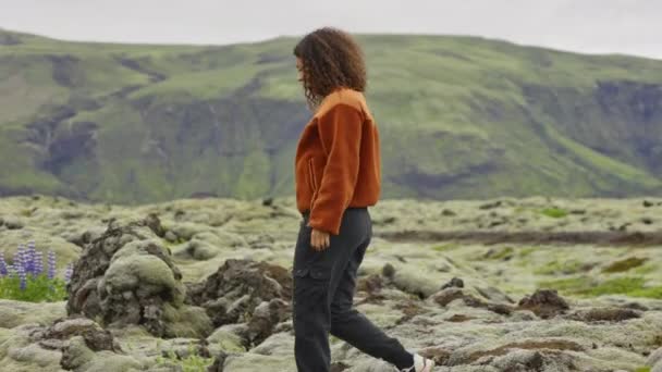 Жінка ходить над мохом покриті скелі в ландшафті — стокове відео