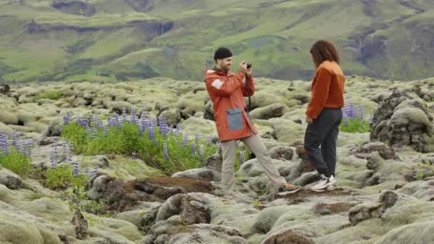 Homem fotografando parceiro de caminhadas em paisagem musgosa — Vídeo de Stock