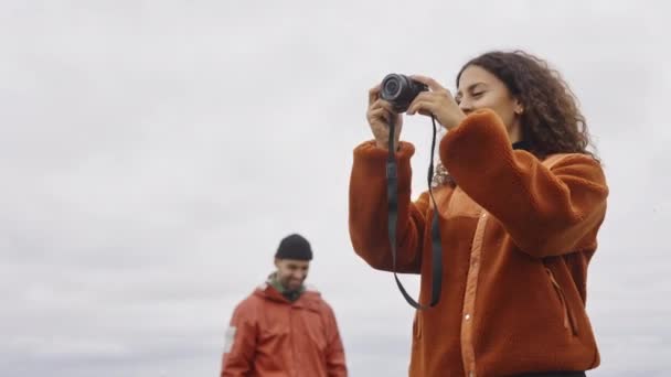 Giovane escursionista femminile che punta al partner sotto il cielo nuvoloso — Video Stock