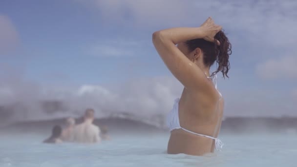 Mujer joven ajustando el cabello en Lagoon Geothermal Spa — Vídeos de Stock