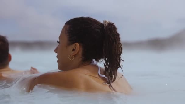 Vrouw vasthouden vriendje in lagune geothermische spa — Stockvideo