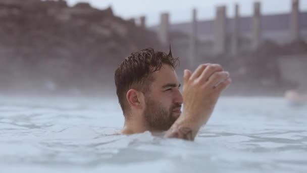 Mladý muž relaxace v Lagoon geotermální lázně — Stock video