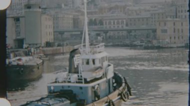 1970 'lerin Korsika' sındaki bu 8 mm 'lik filmde rıhtımda gezinen bir römorkör rıhtıma ve tepe kenarındaki şehir manzarasına karşı çekiliyor..