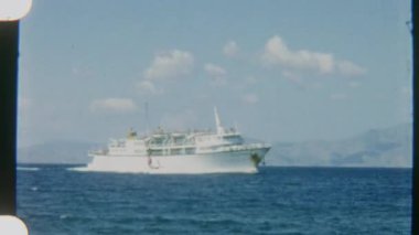 Okyanusta ilerleyen beyaz bir yolcu gemisinin sakin bir görüntüsü. Durmaksızın küçük bir adaya doğru hareket ediyor. 8 mm 'lik bir filme çekiliyor..