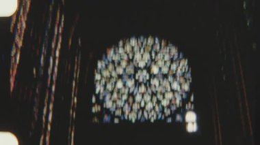 Reims Katedrali 'nin çeşitli renklerde karmaşık tasarımları olan dairesel boyalı cam bir gül penceresi 8 mm' lik bir filme kaydedilmiştir. Kamera yaklaştıkça yavaş yavaş odak noktasına geliyor.