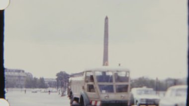 Gündüz vakti çekilen 8 mm 'lik filmle çekilen Luxor Obelisk yakınlarındaki Place de la Concorde' da arabalar ve bisikletçiler hareket ediyor..