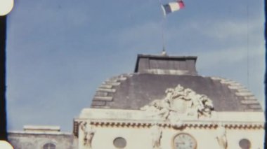 Fransız bayrağı Paris 'te Adalet Sarayı' nda dalgalanır. Heykeller ve saatlerle süslenir ve temiz bir gökyüzü altında 8 mm 'lik bir filme çekilir..