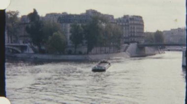 Paris 'teki Seine Nehri boyunca ilerleyen bir mavnanın 8mm' lik Retro filmi. Arka planda binalar ve bir köprü var. Huzurlu ve tarihsel bir havayı yakalıyor..