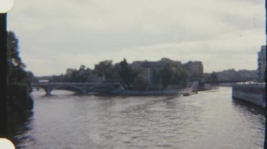 Paris 'teki Seine Nehri' nde klasik su yolları ve şehir manzarasıyla gezinen bir mavnanın 8mm 'lik klasik filmi..