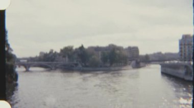 Paris 'ten geçen Seine Nehri' nin sakin bir görüntüsü, 8 mm 'lik filmle çekildi, kıyıları boyunca bir köprü ve binalar sergilendi..