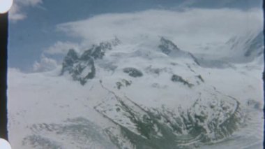 8 mm 'lik filmle çekilen karla kaplı dağların nefes kesici görüntüsü, karlı manzaranın enginliğini ve güzelliğini gösterirken nostaljik ve huzurlu bir görsel hava yaratıyor..