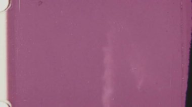 Siluetli insanlar pembe ışıkta parlayan bir fıskiyeyi izliyorlar, nostaljik ve sinematik bir şekilde 8mm 'lik klasik bir filme çekiliyorlar..