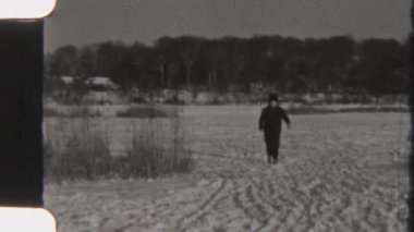 Bir kadın karlı bir arazide paten kayıyor, 8 mm 'lik filme çekiliyor, nostaljik ve barışçıl bir görsel hava yaratıyor..