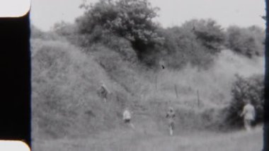 8mm 'lik klasik bir aile görüntüsü, açık hava kamp gezisi sırasında yuvarlanan yeşil tepeleri aşıyor.