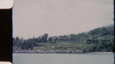 8mm 'lik klasik bir film, bereketli yeşil dağlar ve sık ağaçlar tarafından çerçevelenmiş, sakin bir sahil ve deniz manzarası yakalıyor.