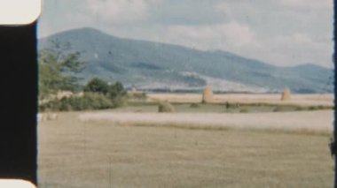 8mm 'lik antika görüntüler, dağ zirvelerinin altına yerleştirilmiş saman yığınlarıyla benekli yama tarlaları yakalıyor ve kırsal kesimin cazibesini uyandırıyor.