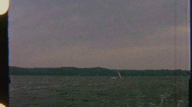 Birkaç yelkenli dalgalı sularda yüzer, 8 mm 'lik bir filme çekilir, dinamik ve hafif çalkantılı bir görsel ortam yaratır..