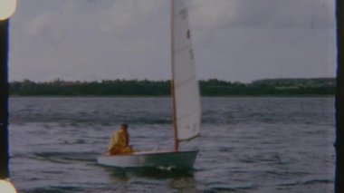 Sarı yağmurluklu bir adam, gündüz vakti çekilen 8 mm 'lik bir filmde, bir su kütlesi üzerinde bir yelkenliyle ilgilenir. Görsel ruh hali sakin ve sakin. Tekne suda süzülürken hafif bir hareketle..