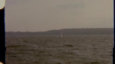 Yelkenliler dalgalı bir denizi aşar, 8 mm 'lik bir filme çekilir, nostaljik ve huzurlu bir görsel ortam yaratır..