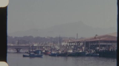 Birkaç tekne 8 mm 'lik bir filmde limanda dinleniyor, durgunlukları suda süzülen küçük bir tekneyle zıtlaşıyor, dingin ve nostaljik bir havayı çağrıştırıyor..