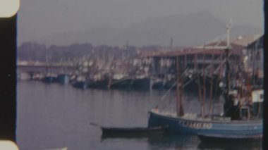 8mm 'lik klasik bir film rıhtımda demirlemiş teknelerle dolu sakin bir limanı, uzak tepelere bakan sakin sulardaki yansımalarını, nostaljik ve sakin bir atmosferi çağrıştırıyor..