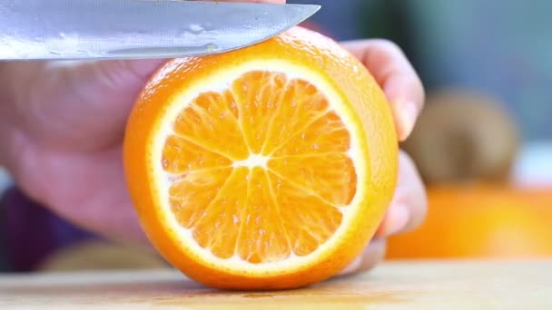 Hand slicing a orange with a knife — Stock Video