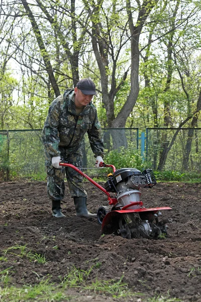 Mann arbeitet im Garten bei der Bodenbearbeitung — Stockfoto