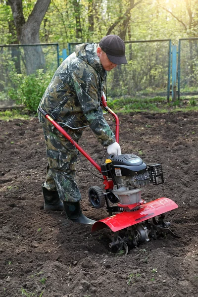Homem trabalhando no jardim preparando cultivador de terra — Fotografia de Stock