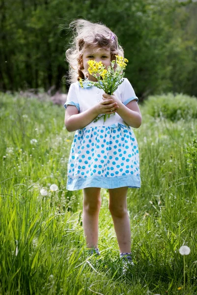 Lilla lockiga flickan med bukett av blommor, — Stockfoto