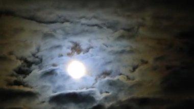 Bulutlu gece gökyüzünde zaman akıp gidiyor.