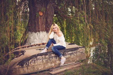 eski bir tekne üzerinde oturma sarı uzun saçları olan genç kadın