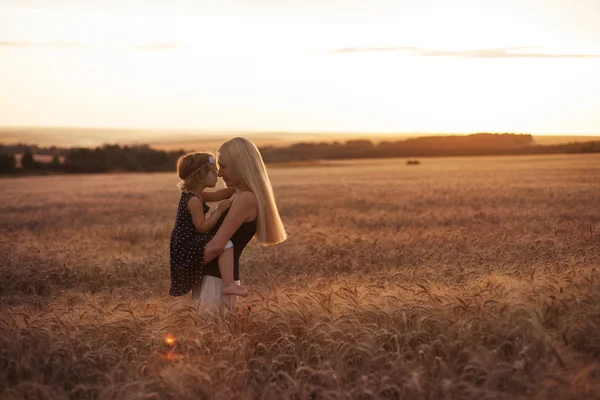 Mãe e filha no campo ao pôr-do-sol — Fotografia de Stock