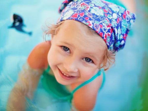 Smiling little girl in the swimming pool at summer — Stock Photo, Image