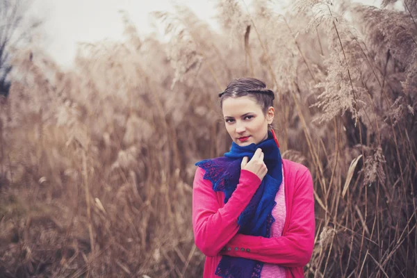 Girl in casual warm clothing posing in reeds — Stock Photo, Image