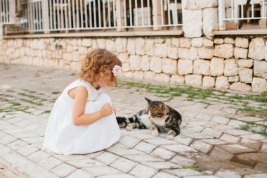 Küçük kız açık kedi ile oynarken
