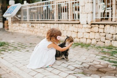 Küçük kız açık kedi ile oynarken