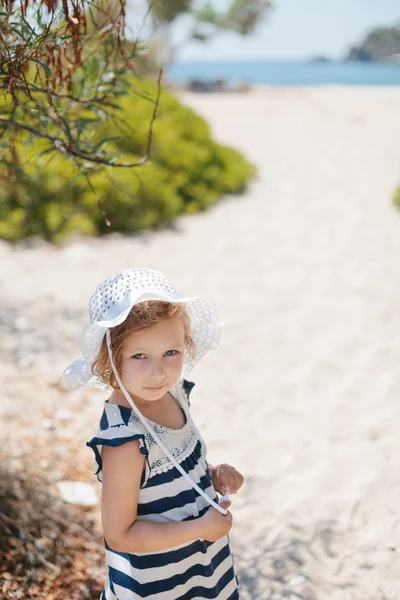 Adorable niña sonriente feliz con el pelo rizado en la playa vaca —  Fotos de Stock