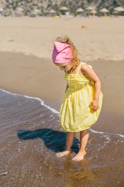 Adorable niña sonriente feliz con el pelo rizado en la playa vaca —  Fotos de Stock