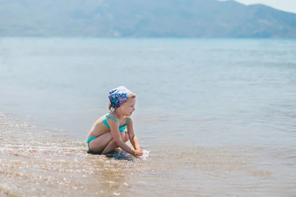 해변 휴가에 곱슬 머리를 가진 사랑 스러운 행복 미소 어린 소녀 — 스톡 사진