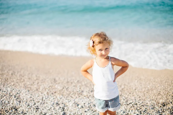 Adorabile felice sorridente bambina con i capelli ricci sulla spiaggia vaca — Foto Stock