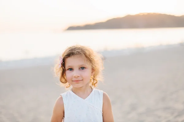 Schattig gelukkig lachend meisje met krullend haar op strand vaca — Stockfoto