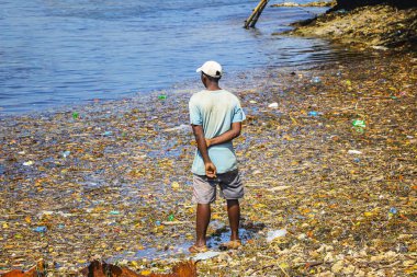 Kenya, Wasini Adası 'ndaki çöpte bir adam duruyor. Bunlar Hint Okyanusu, Afrika 'daki plastikler..