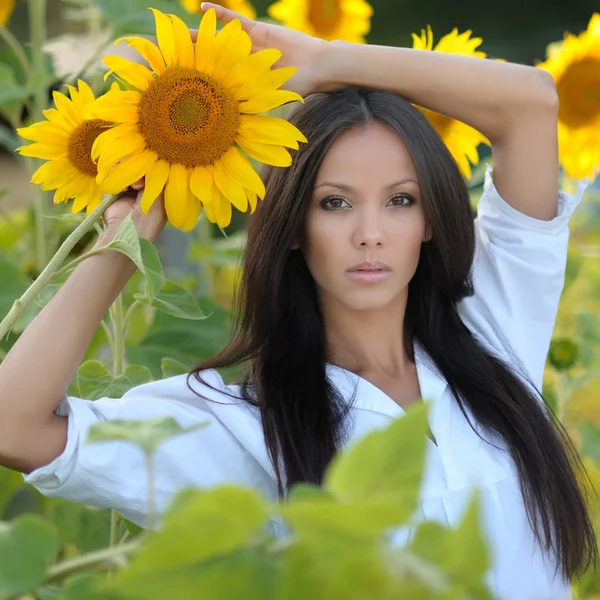 Retrato de una hermosa chica con flores en el verano — Foto de Stock