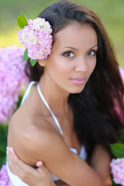 Ritratto di una bella ragazza con fiori in estate — Foto Stock