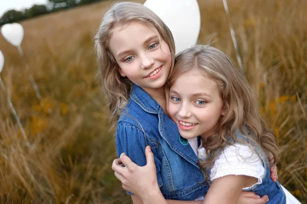 Portret van een kleine meisjes in een veld met witte ballonnen — Stockfoto