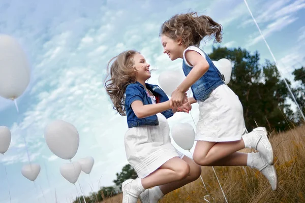 Retrato de um meninas em um campo com balões brancos — Fotografia de Stock