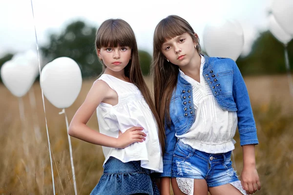 Retrato de um meninas em um campo com balões brancos — Fotografia de Stock