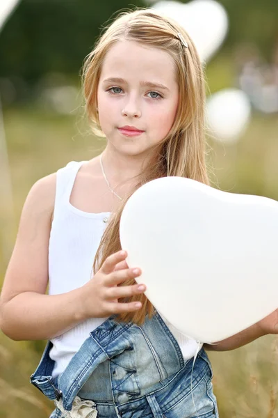 Retrato de una niña en un campo con globos blancos — Foto de Stock