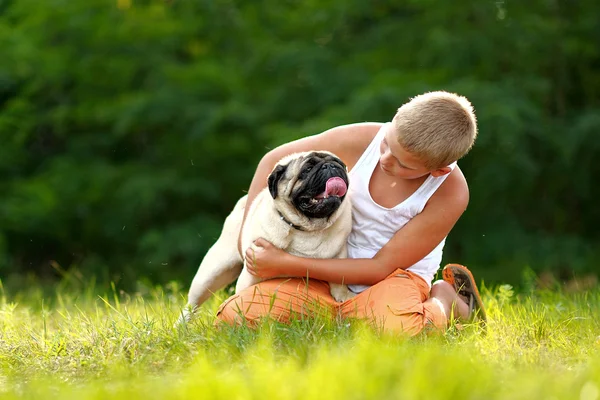 Porträtt av en pojke med hund mops — Stockfoto